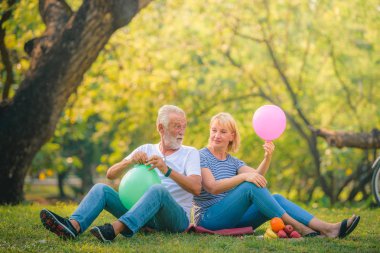Yaşlı çift gün batımında bahçede eğleniyor. Yaşlı aşıklar konsepti.