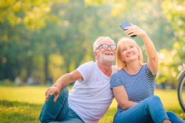 Yaşlı çift gün batımında bahçede eğleniyor. Yaşlı aşıklar konsepti.