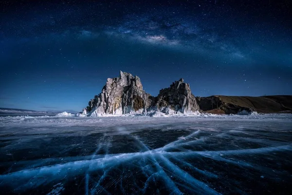 俄罗斯西伯利亚贝加尔湖冰水中自然破冰的Shamanka岩石和银河的景观. — 图库照片