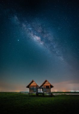 Landscape image of milky way over the abandoned twin house near Chalerm Phra Kiat road in Thale Noi, Phatthalung, Thailand clipart