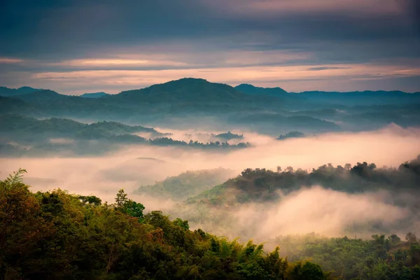 Foggy in the mountains with dramatic sky at sunrise