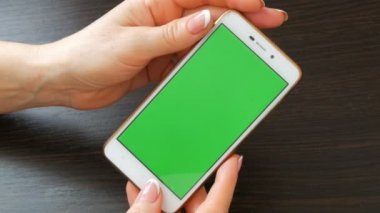 Eller güzel Fransız manikür ile yeşil ekran ile beyaz bir akıllı telefon alıyorum. Smartphone, Smartphone yeşil ekran ile tutarak kullanarak