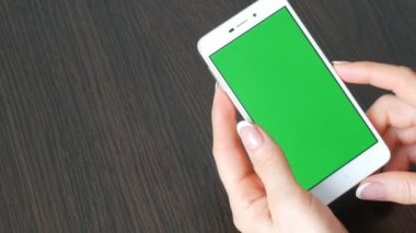 Eller güzel Fransız manikür ile yeşil ekran ile beyaz bir akıllı telefon alıyorum. Smartphone, Smartphone yeşil ekran ile tutarak kullanarak