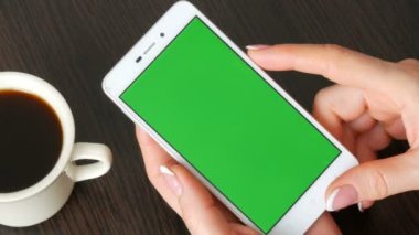 Eller güzel Fransız manikür ile beyaz bir akıllı telefon ile yeşil perde beyaz kahve götüreceğim. Smartphone, Smartphone yeşil ekran ile tutarak kullanarak