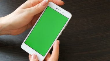 Eller güzel Fransız manikür ile yeşil ekran ile beyaz bir akıllı telefon alıyorum. Smartphone, Smartphone yeşil ekran ile tutarak kullanarak