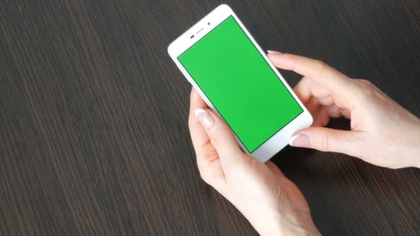 Жіночих рук з красивою французького манікюру Візьміть білий смартфон з зелений екран. За допомогою смартфона, проведення смартфон з зелений екран — стокове відео