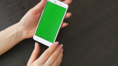 Eller güzel Fransız manikür ile yeşil ekran ile beyaz bir akıllı telefon alıyorum. Smartphone, Smartphone yeşil ekran ile tutarak kullanarak
