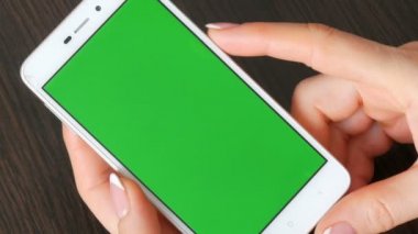 Eller güzel Fransız manikür ile yeşil ekran ile beyaz bir akıllı telefon alıyorum. Smartphone, Smartphone yeşil ekran ile tutarak kullanarak