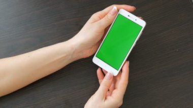 Eller güzel Fransız manikür ile yeşil ekran ile beyaz bir akıllı telefon alıyorum. Smartphone, Smartphone yeşil ekran ile tutarak kullanarak