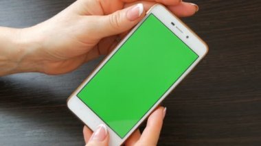 Eller güzel Fransız manikür ile yeşil ekran ile beyaz bir akıllı telefon alıyorum. Smartphone, Smartphone yeşil ekran ile tutarak kullanarak
