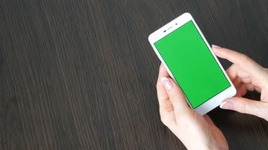Eller güzel Fransız manikür ile yeşil ekran ile beyaz bir akıllı telefon alıyorum. Smartphone, Smartphone yeşil ekran ile tutarak kullanarak