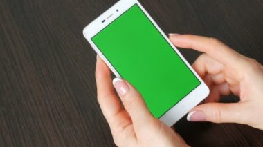 Eller güzel Fransız manikür ile yeşil ekran ile beyaz bir akıllı telefon alıyorum. Smartphone, Smartphone yeşil ekran ile tutarak kullanarak