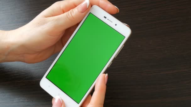 Les mains féminines avec une belle manucure française prennent un smartphone blanc avec écran vert. Utilisation de Smartphone, tenant Smartphone avec écran vert — Video