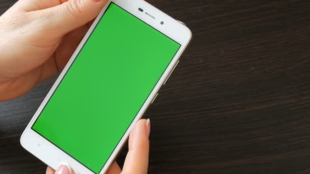 Γυναικεία χέρια με όμορφο γαλλικό μανικιούρ Πάρτε ένα λευκό smartphone με πράσινη οθόνη. Χρησιμοποιώντας το Smartphone, κρατώντας Smartphone με πράσινη οθόνη — Αρχείο Βίντεο