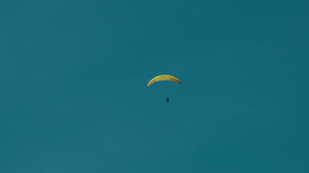 Silhouette di parapendio giallo che vola contro il cielo — Video Stock