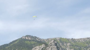 Sarı yamaçparaşütü gökyüzüne karşı uçan silüeti