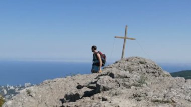 Genç adam dağın zirvesine yürür. Başarı hedefin kendini motivasyon üstesinden