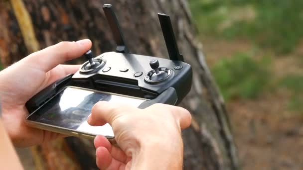 L'homme tient la télécommande du drone ou du quadrocopter et dirige le vol — Video