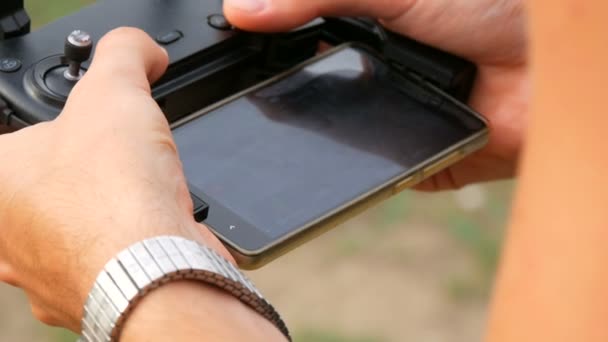 L'homme tient la télécommande du drone ou du quadrocopter et dirige le vol 