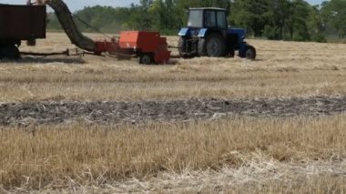 Buğday bir arka planda çekik traktör sürmek ve ürün mows