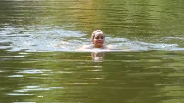 젊은 여성이 여름에 야생 강에 목욕을 합니다. 자연 자연 조건에서 강에 내려면 — 비디오
