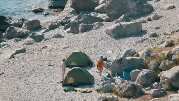 Rotsachtige kust van de Zwarte Zee waarop er weinig mensen met tenten zijn. Kamperen in het wild plaatsen — Stockvideo
