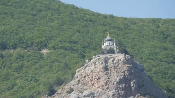 Вид на красивую Форосскую ордынскую церковь, которая стоит на вершине среди скалистых и зеленых крымских гор — стоковое видео