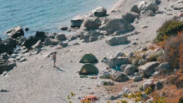 Rotsachtige kust van de Zwarte Zee waarop er weinig mensen met tenten zijn. Kamperen in het wild plaatsen — Stockvideo