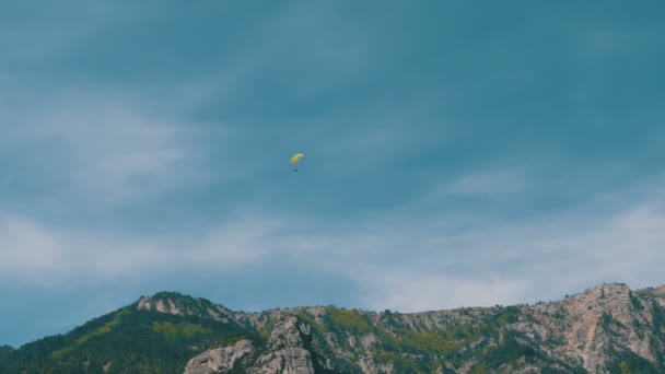 Silhouet van gele paraglider vliegen tegen de hemel — Stockvideo