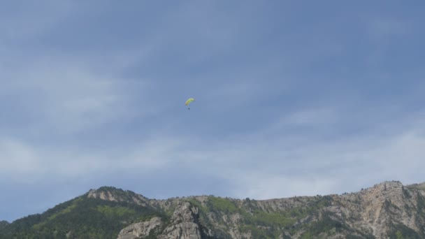 Silhouette des gelben Gleitschirms fliegt gegen den Himmel — Stockvideo