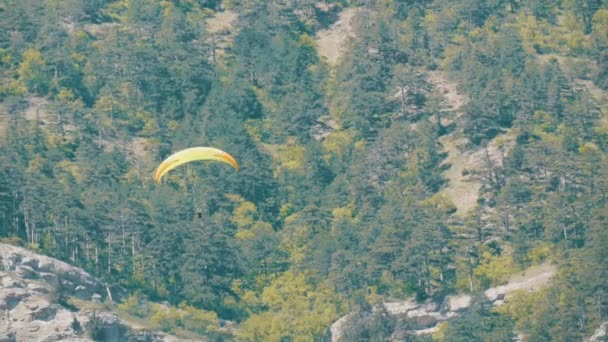 Parapente jaune vole sur un fond de montagnes vertes rocheuses de Crimée — Video