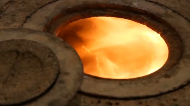 Zeer oude bakstenen oven met gietijzeren pannenkoeken, in welke brand brandwonden. Een persoon sluit de oven met een speciaal apparaat — Stockvideo