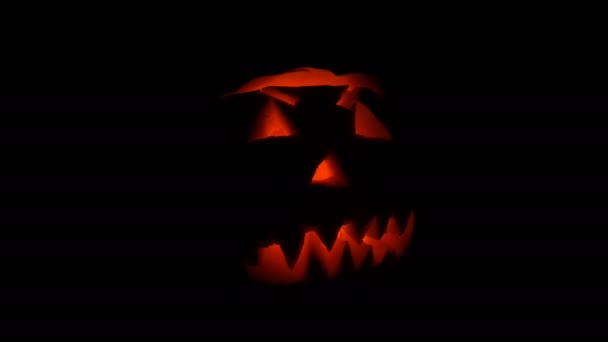 Lysande grimas ristade på Halloween pumpa att de dag av alla heliga i mörkret — Stockvideo