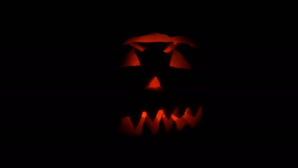 Lichtgevende grimas gesneden op de Halloween pompoen aan de dag van All Saints in donker — Stockvideo