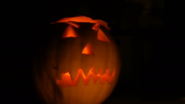 Luminosa mueca tallada en la calabaza de Halloween para el Día de Todos los Santos en la oscuridad — Vídeos de Stock