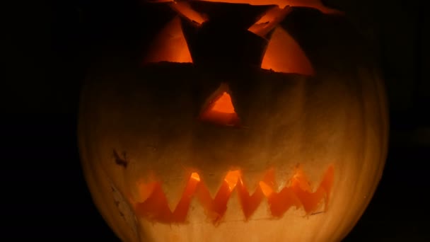 Lysande grimas ristade på Halloween pumpa att de dag av alla heliga i mörkret — Stockvideo