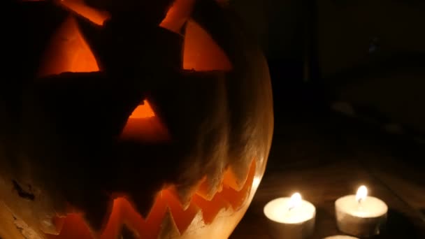 Abóbora terrível Halloween cercada por muitas velas no escuro — Vídeo de Stock