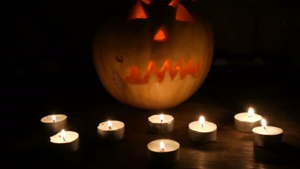 Hrozný Halloween dýně, obklopené mnoha svíčky ve tmě — Stock video