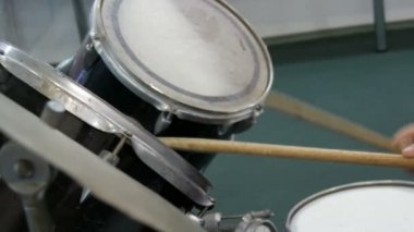 Genç davul seti oynamak için öğrenme. Davul sopa üzerinde farklı davul zili çalmak