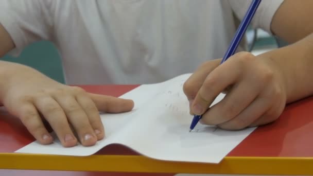 Tiener jongen leert om met de linkerhand te schrijven — Stockvideo