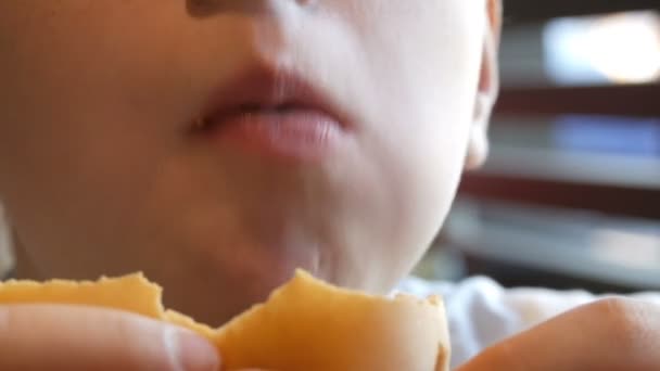 뚱뚱한 소년 먹는 치즈 버거 얼굴 클로즈업입니다. 건강에 해로운 음식, 패스트 푸드 — 비디오