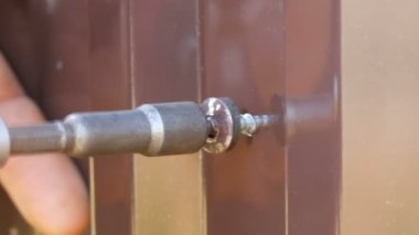 El tornavida ve vidalar demir sac yakın görünüm kesti. Çiti tamir Mens eller