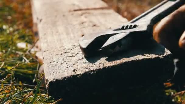 Male hands tighten wrench and screw on a wooden board close up view — Stock Video