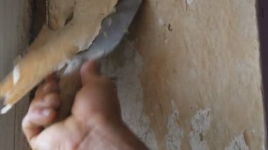 Adam özel spatula ile eski duvar kağıdı soyulması. Sarı, eli ayağı tutmaz duvar kağıdı duvar ev onarım yakın çekim