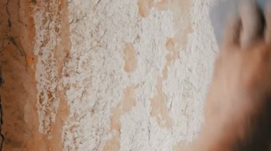 Adam özel spatula ile eski duvar kağıdı soyulması. Sarı, eli ayağı tutmaz duvar kağıdı duvar ev onarım yakın çekim