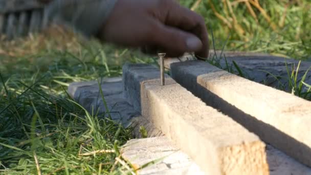 Homme martelant utilisé ongle long dans de vieilles planches — Video