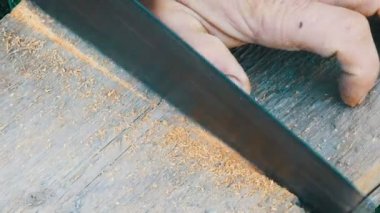 Tahta testereyle kesen bir adam.