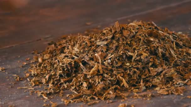 Mani maschili raggrinziscono foglie secche di tabacco sul tavolo — Video Stock