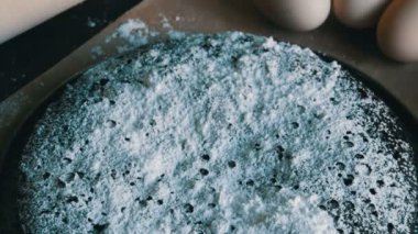 Toz şeker, yumurta ve ahşap oklava bir arka plan ile ev yapımı fırında çikolatalı browni kek