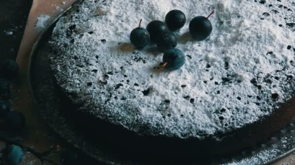 Schokoladenkuchen Brownie großzügig mit Puderzucker bedeckt stilvoll neben den blauen Beeren liegen — Stockvideo